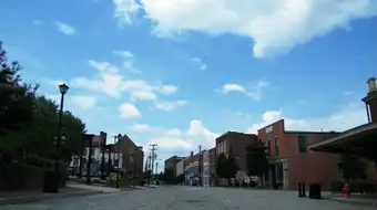 Historic brick buildings along a quiet downtown street in Petersburg, Virginia. The 19th-century storefronts are largely intact, with few signs of recent investment.
