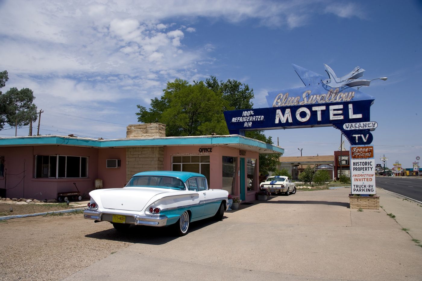 The Blue Swallow Motel on Route 66 in Tucumcari, New Mexico. A 1958 Buick sits in front of the iconic neon sign.